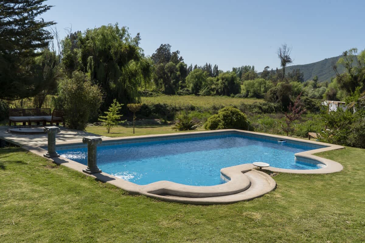 Unique shaped pool set in a wide green lawn w/ open views