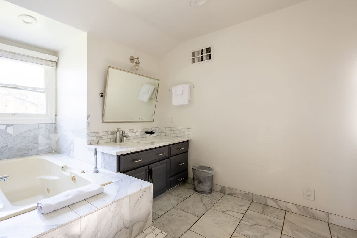 Elegant marble master bath with soaking tub & double vanity. Perfect place to unwind after golf in Gilroy, wine tours in San Martin, or a corporate retreat in Morgan Hill.