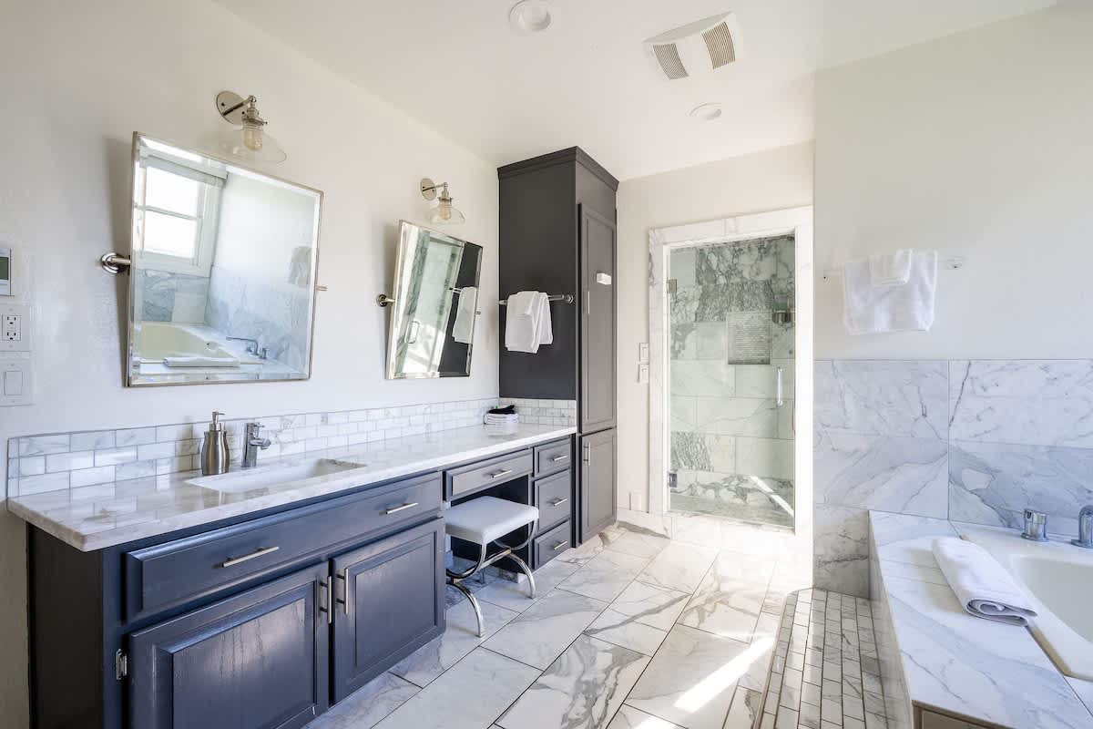 Bright spa-style bathroom with dual vanities, marble finishes, walk-in shower & large soaking tub. Stocked with hair dryer, shampoo & essentials—perfect for families, golfers & wine lovers visiting San Martin, Gilroy & Morgan Hill.