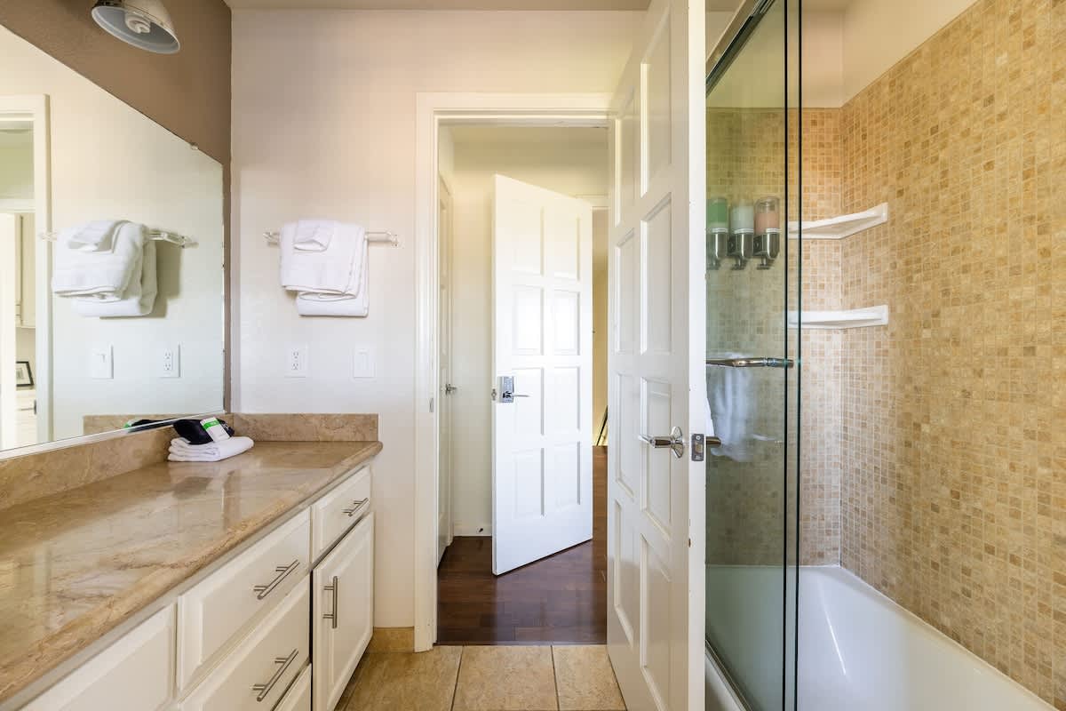 Private upstairs en-suite with granite vanity, glass shower/tub combo, and direct access from the Shoreditch Bedroom.