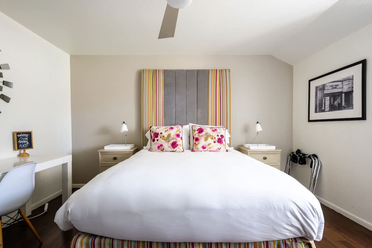 SOHO Bedroom – Bright and modern upstairs retreat with a queen bed, work desk, and vibrant accents. Perfect for families, wine lovers, golfers, or corporate stays looking for style and comfort.