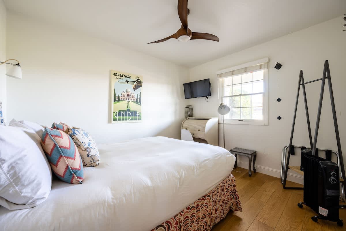 Bricklane Bedroom: cozy downstairs retreat with queen bed, TV, and modern ceiling fan. Perfect for families, wine lovers, golfers, or professionals seeking comfort after a day in San Martin’s vineyards or on the fairway.