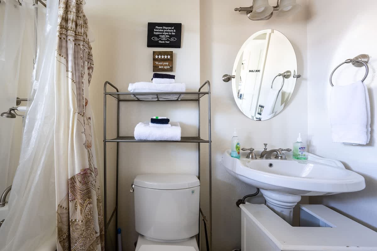 Bright downstairs bathroom with a shower/tub combo, vanity sink, and fresh linens. Conveniently located near the Bricklane Bedroom and stocked with essentials for comfort and ease
