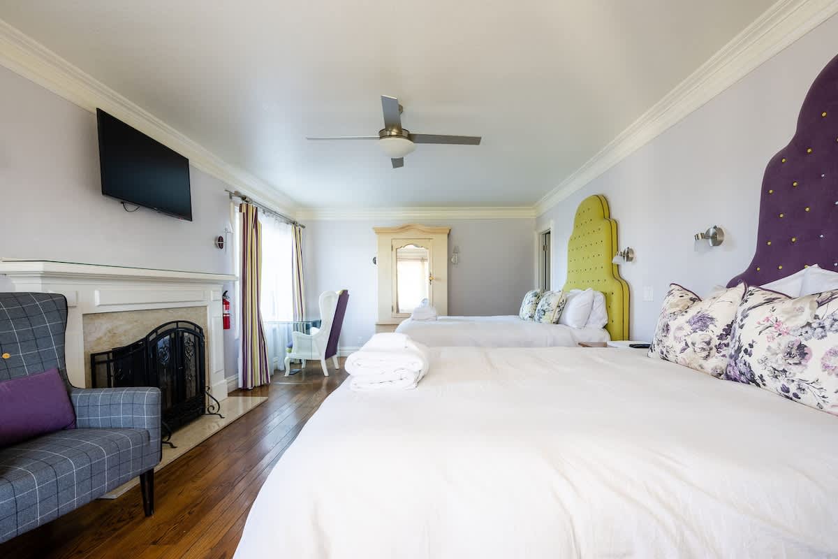 Spacious double-queen room with fireplace, TV, and cozy seating. Perfect for families needing extra space, wine country getaways, golf trips, or corporate retreats.