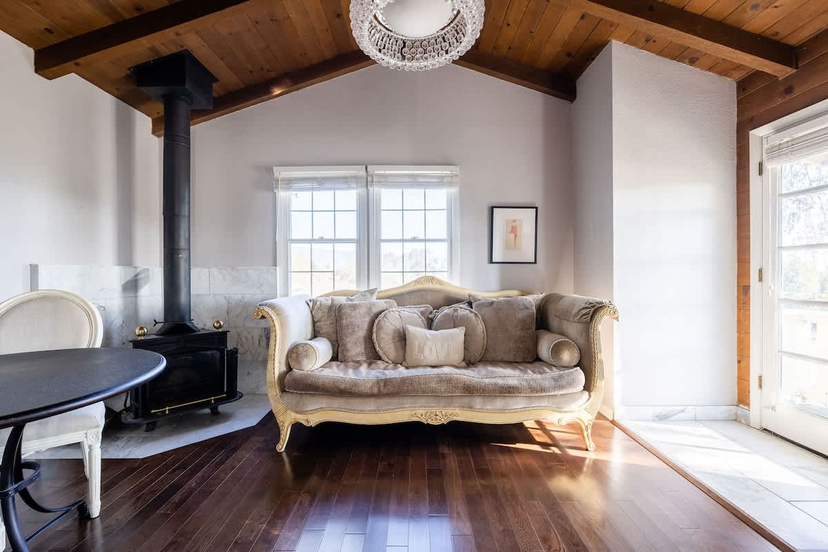 Unwind in your private master suite lounge, complete with elegant seating and a warm wood-burning stove—perfect for morning coffee, late-night talks, or curling up after wine tasting.