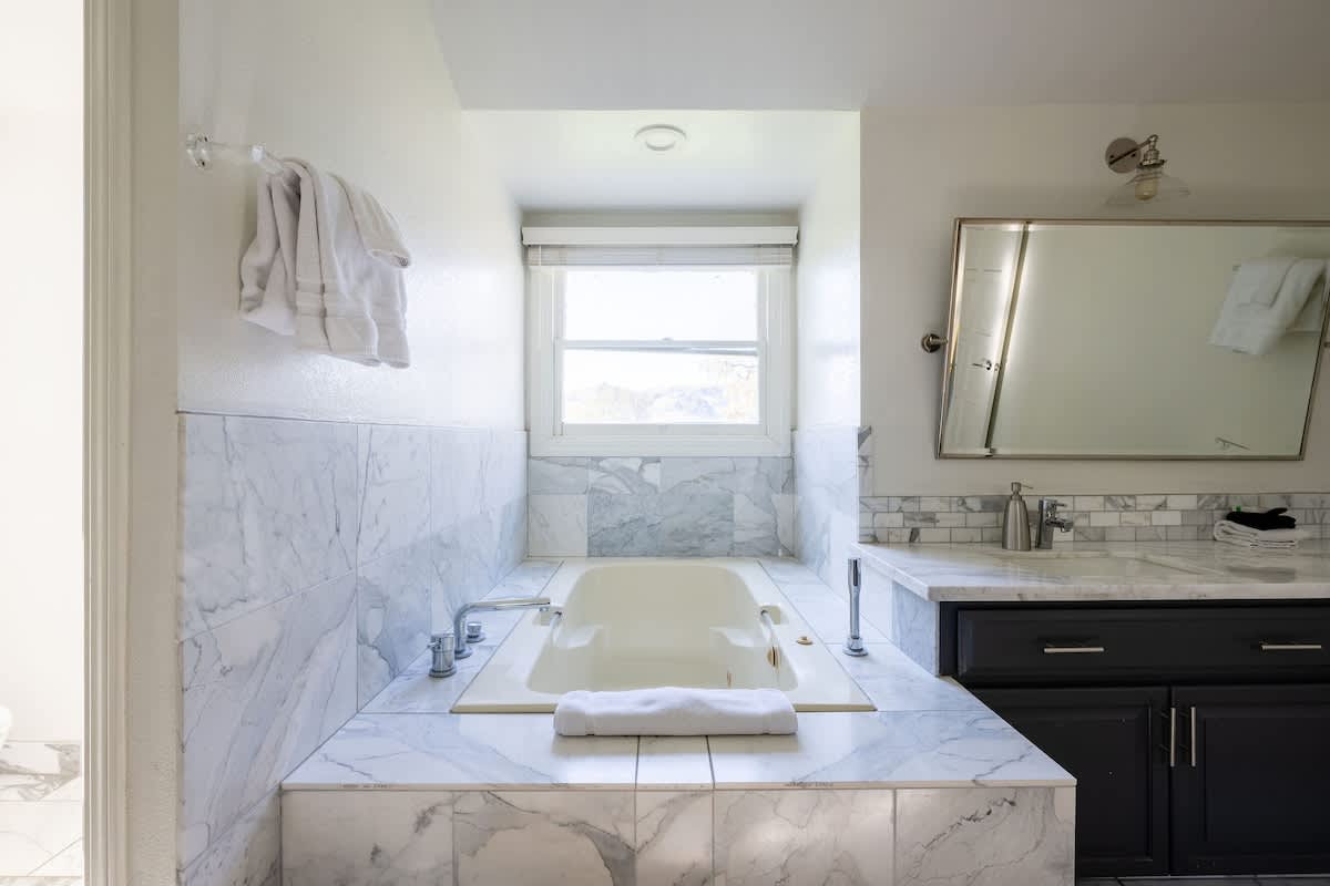 Relax in the marble soaking tub with serene views. Ideal for unwinding after San Martin wine tours, Gilroy golf, or a family retreat in Morgan Hill.