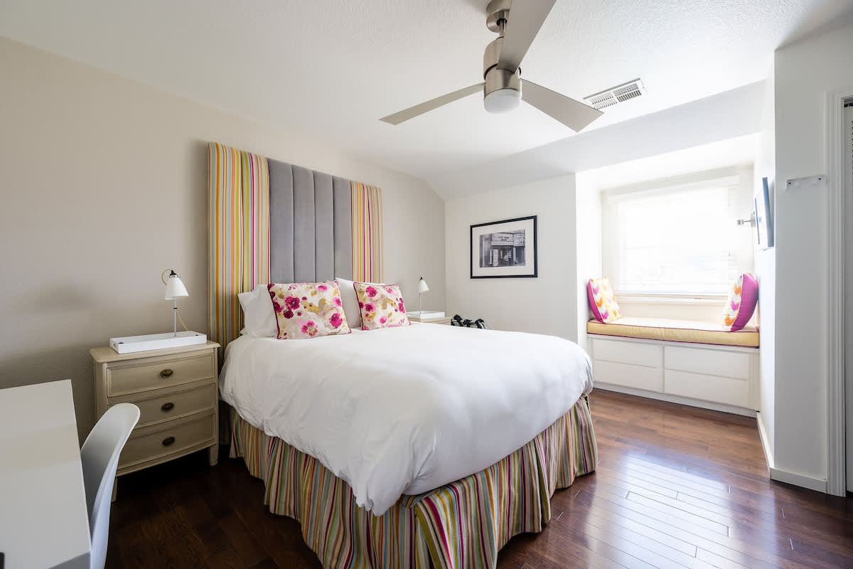 SOHO Bedroom – Stylish upstairs retreat with a plush queen bed, bright windows, and a cozy reading nook. Perfect for families, wine country travelers, golfers, or corporate guests seeking comfort and privacy.