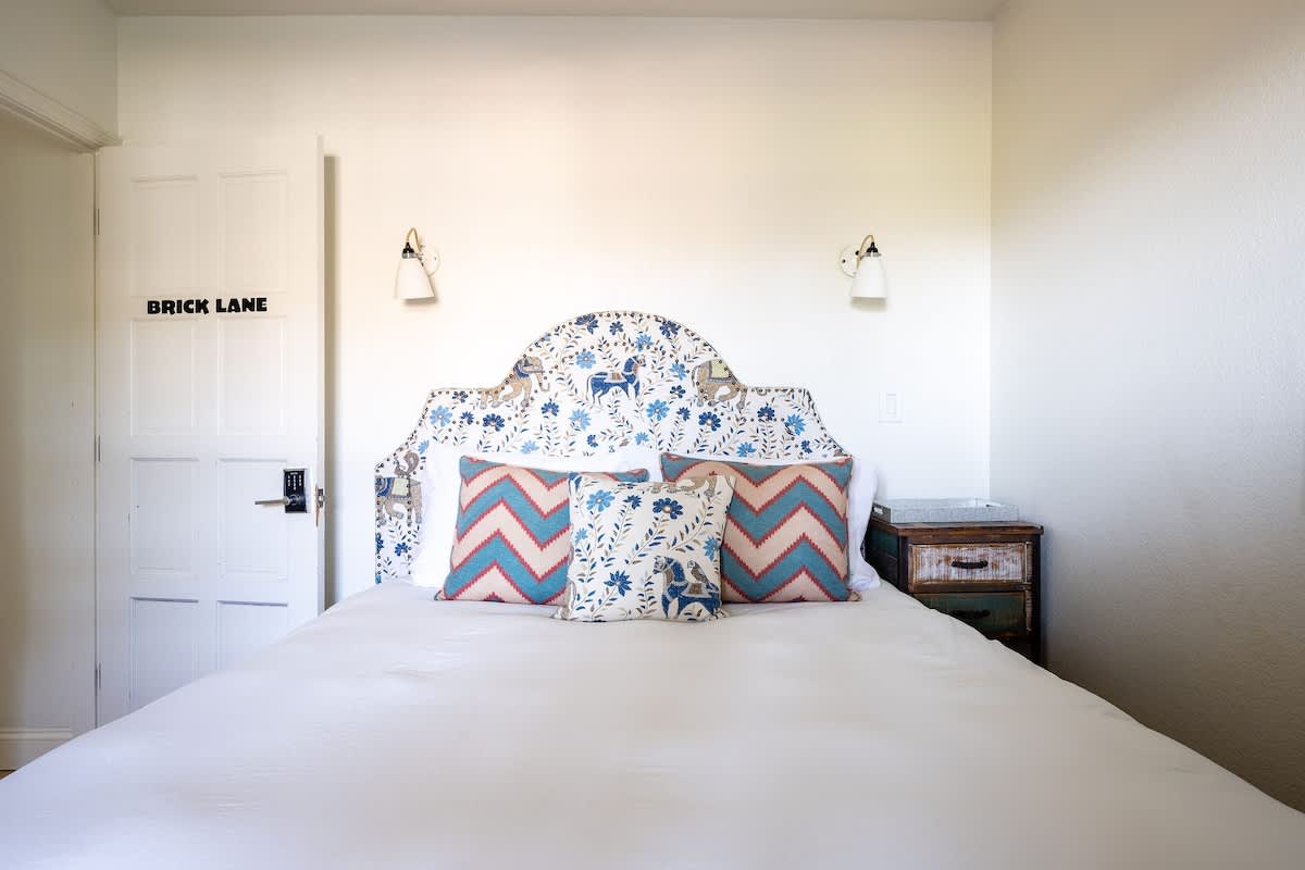 Cozy Bricklane Bedroom with queen bed, plush linens, and warm style. Perfect for families visiting San Martin, wine country travelers, or guests exploring nearby golf resorts and Silicon Valley.
