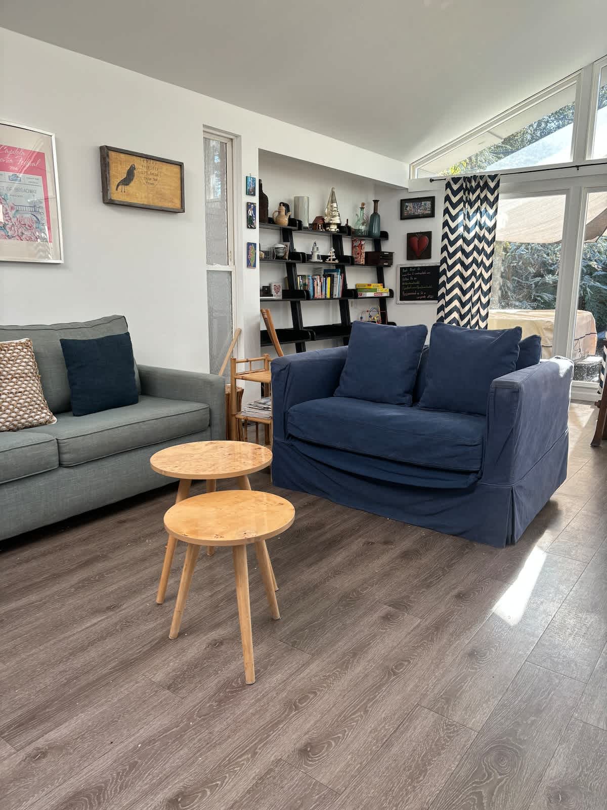 Bright living room with coastal décor, curated bookshelves, and cozy seating. Perfect for families to gather, couples to relax, or business travelers to recharge in style.