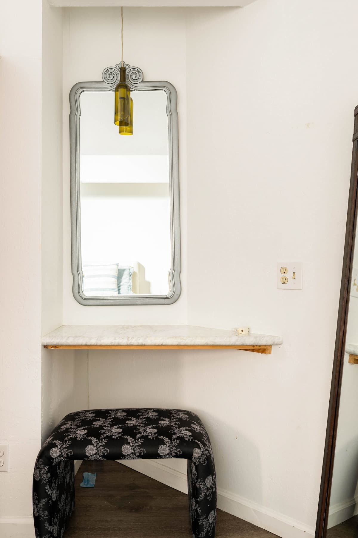 Charming vanity nook with marble counter and cozy stool—perfect for couples getting ready, families needing extra space, or professionals on the go.