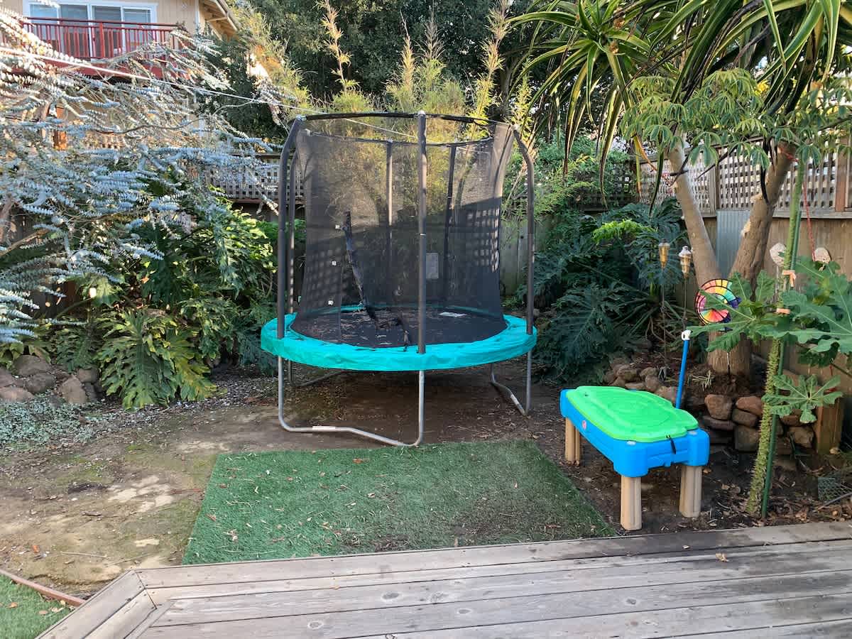 Perfect for families — the backyard includes a trampoline and play area where kids can burn off energy while adults relax on the patio or soak in the hot tub.