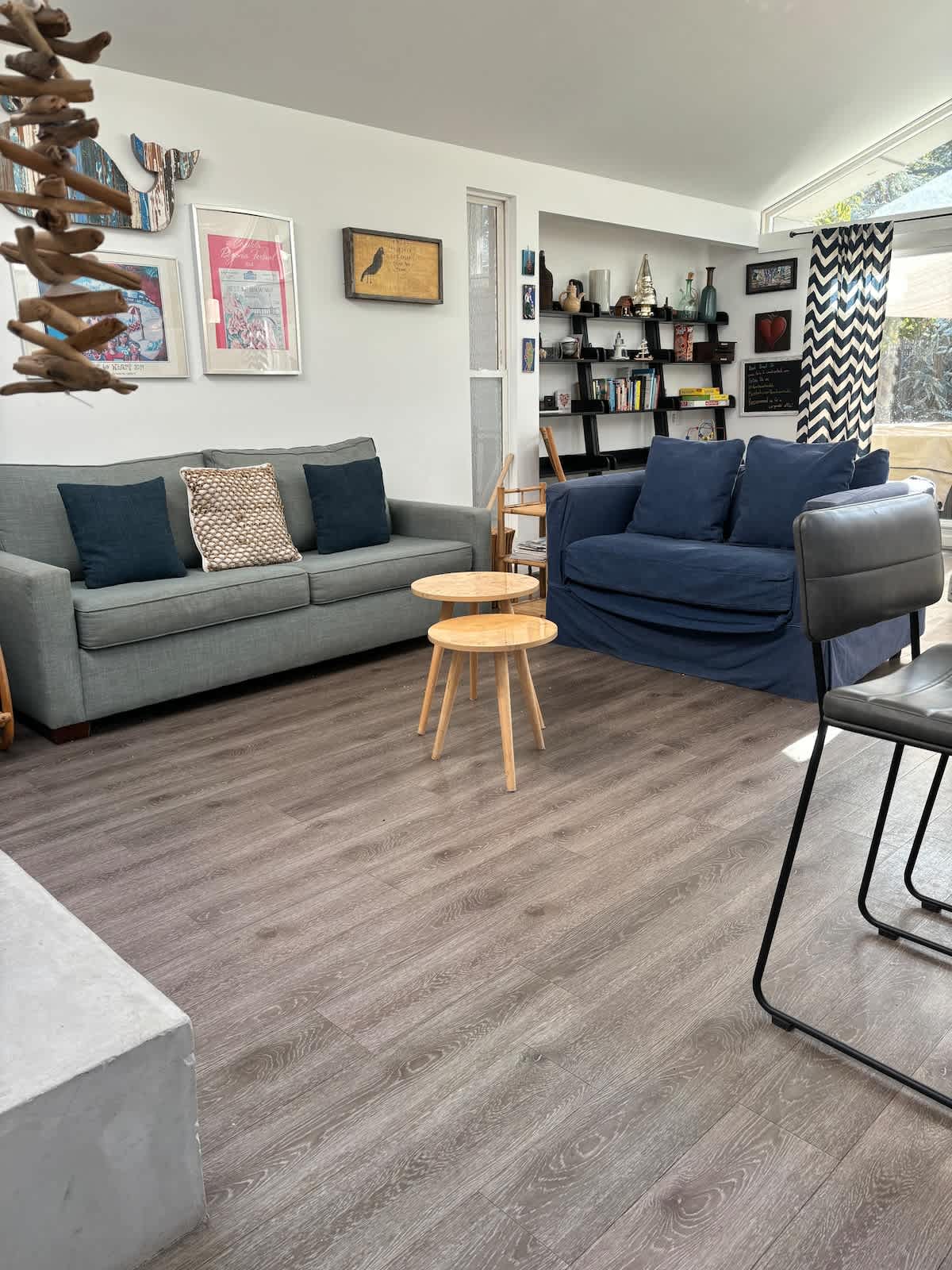 Relax in the spacious living room with comfy seating, natural light, and books to enjoy—perfect for family game nights, a cozy evening for two, or unwinding after a busy workday.