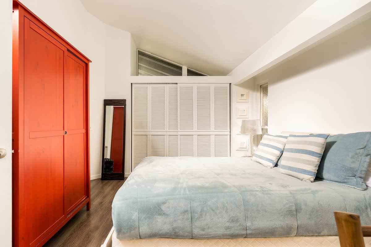 Spacious bedroom with a queen bed, bold décor, and ample storage. Ideal for couples seeking comfort, families needing space, or remote workers wanting a restful retreat after a productive day.