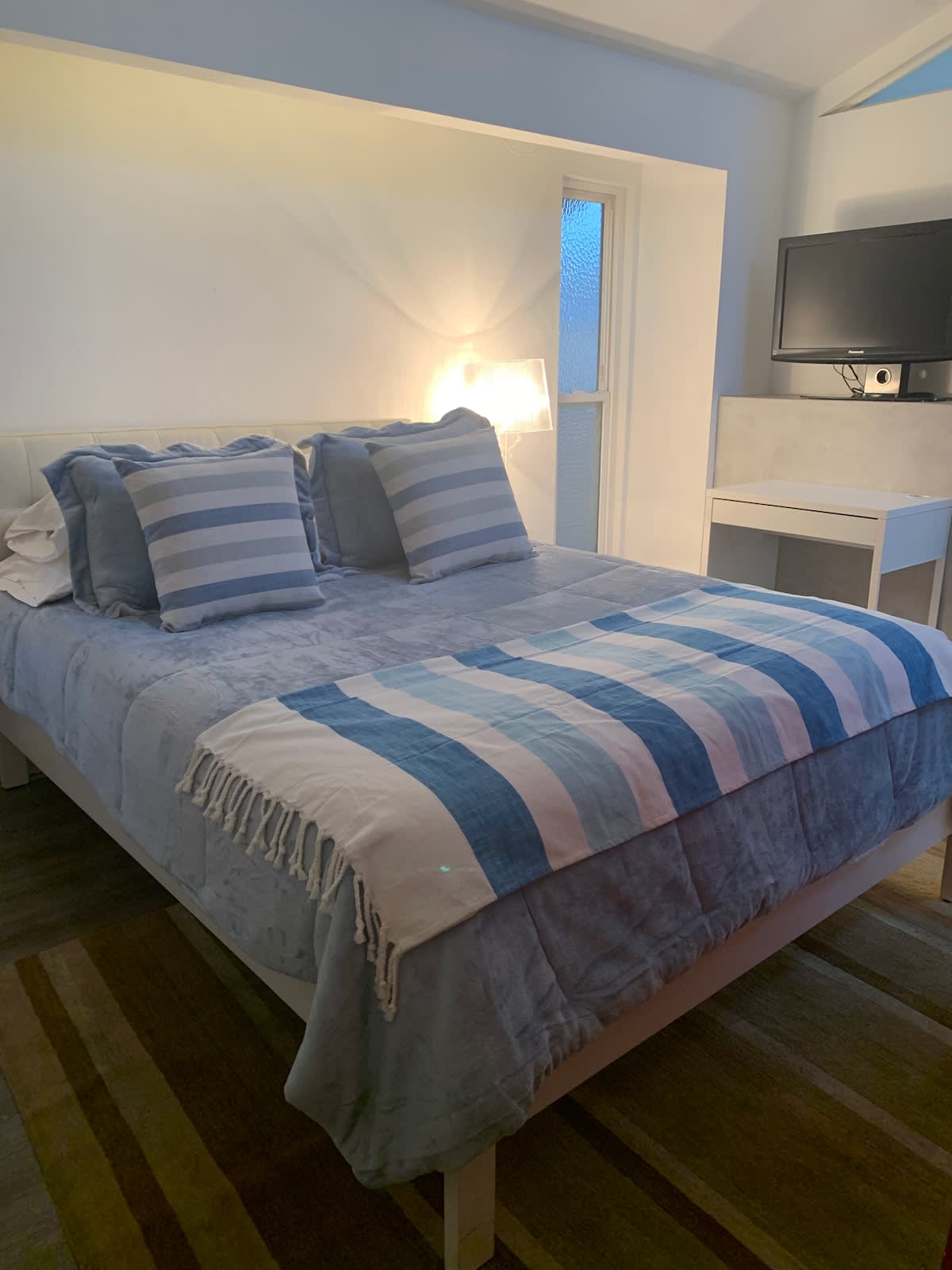 Relax in a cozy bedroom with a plush queen bed, soft linens, and smart TV—perfect for couples, families, or business travelers.