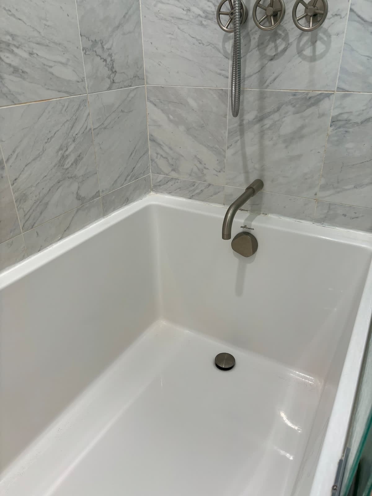 Unwind in the deep soaking tub, complete with modern fixtures and marble tile accents—perfect for a spa-like retreat after a day at the beach or exploring.