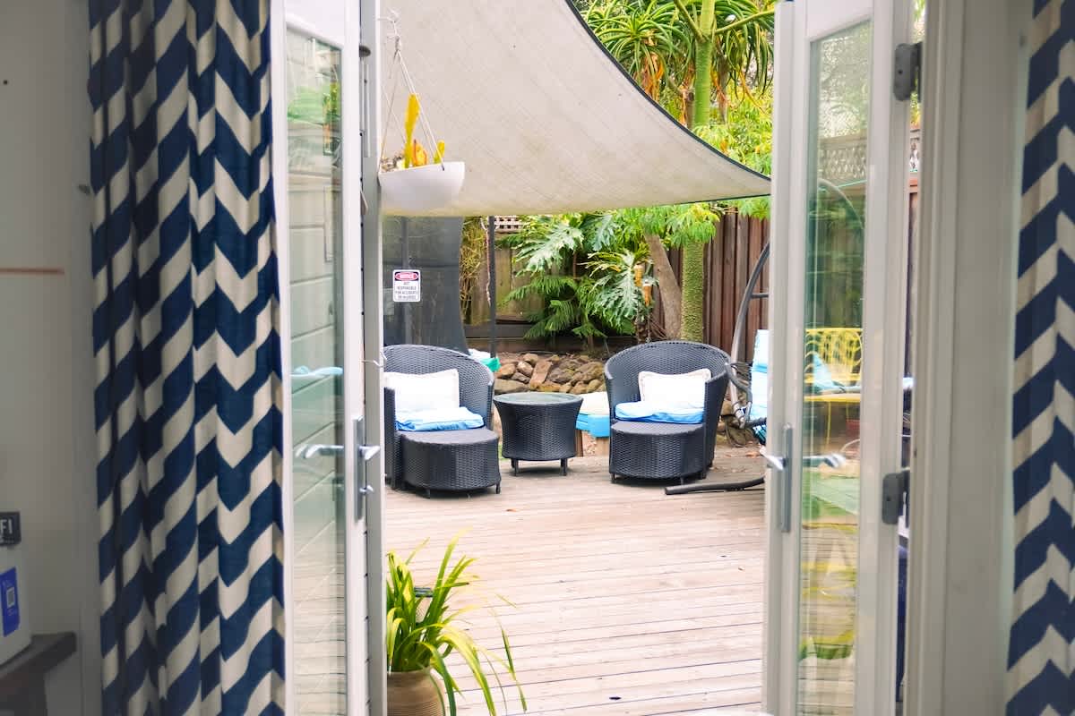 Step out the French doors into your private backyard retreat — shaded seating, lush greenery, and fresh coastal air create the perfect spot to relax whether you’re here for romance, family fun, or a business recharge.