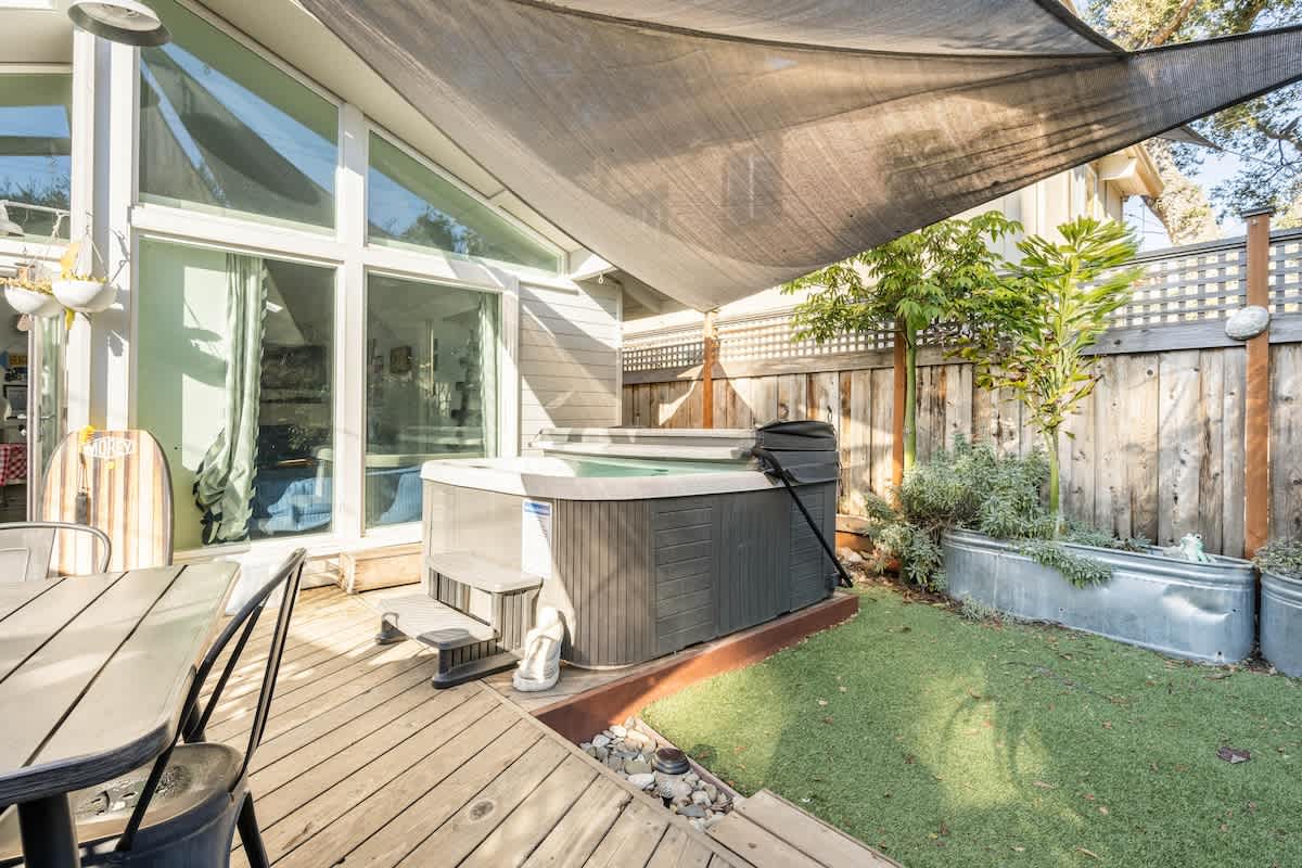 Spacious patio with hot tub and dining — perfect for couples to unwind, families to gather, or professionals to relax after a productive day.