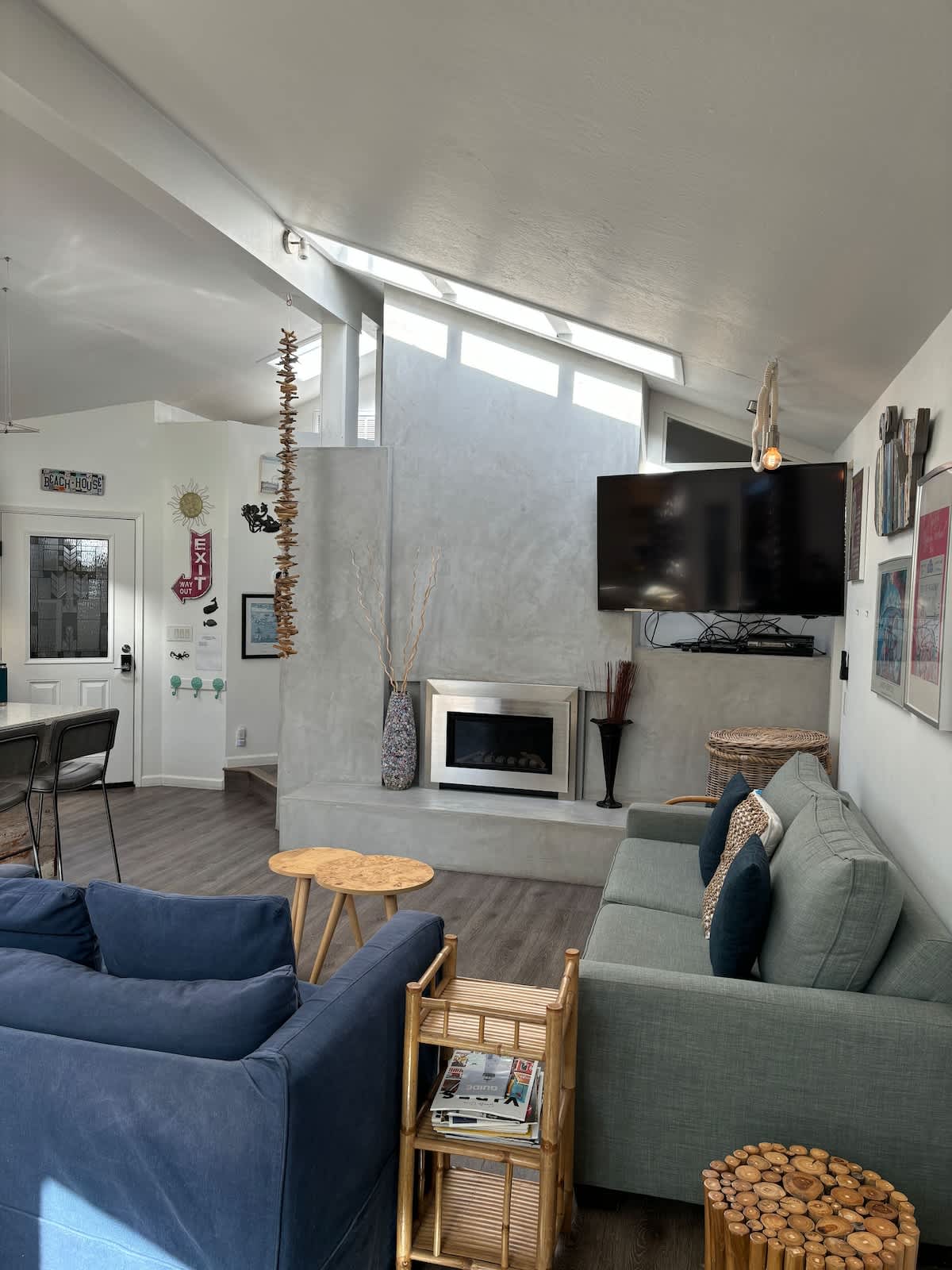 Bright living room with smart TV, fireplace, and a sleeper sofa — perfect for family movie nights, couples relaxing after the beach, or work travelers unwinding in comfort.