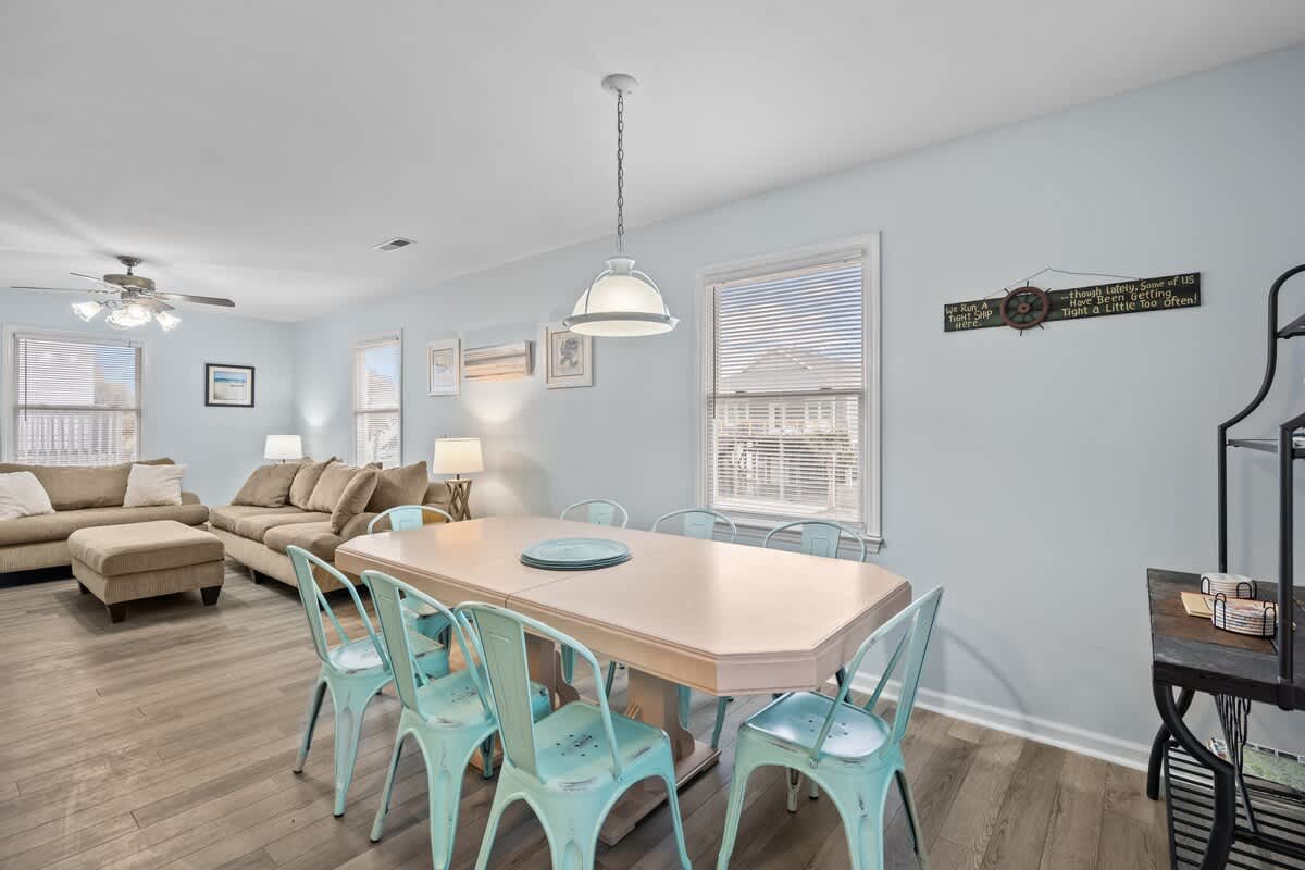 The dining table with its antiqued chairs has comfortable seating for 8 (additional seating available at kitchen island).
