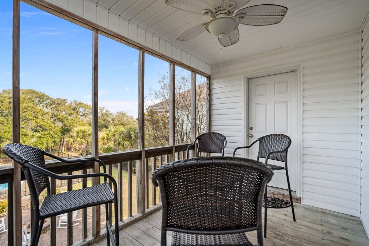 Seating for four on the screened in back Porch with ceiling fan.