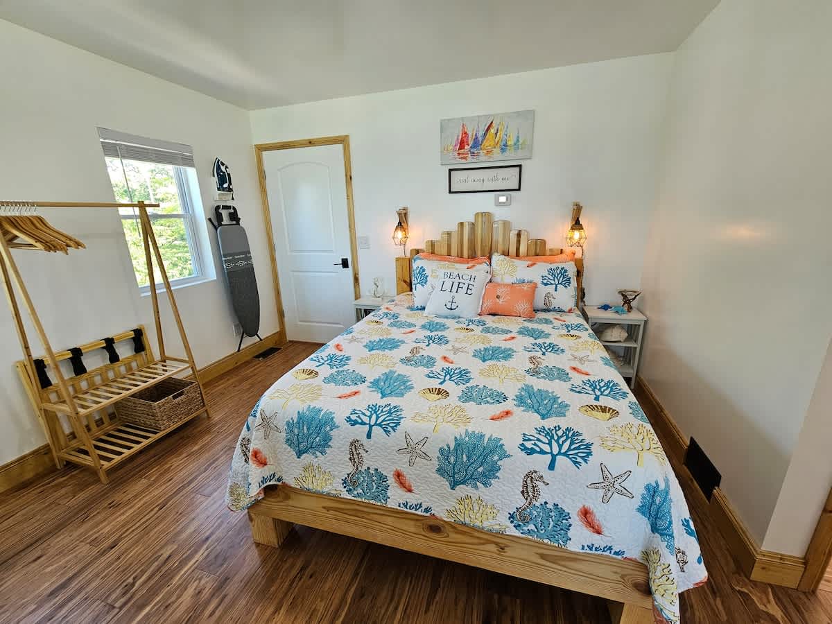 doorway that leads to the stairwell and the queen size bed that awaits