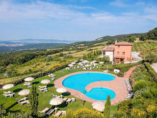 Apartments behind a circular pool in Tuscany