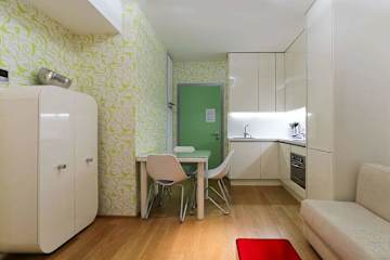 Sleek cupboards in a kitchen with sofa and table