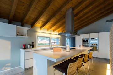 Four bar stools under an island in a kitchen