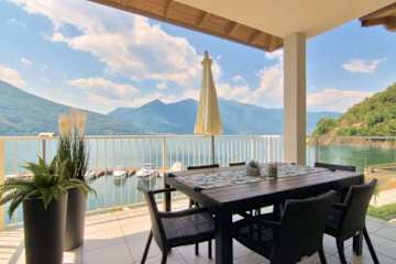 Two plastic chairs on a wooden terrace next to a pool