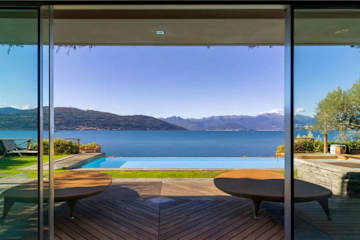 Three loungers at the end of a lakeside swimming pool