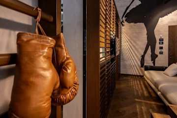 Brown leather boxing gloves hanging on a wall