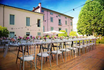 Outdoor table with flowers in front of a pink villa
