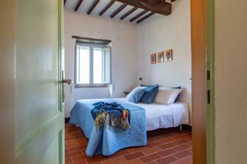 Double bed with white sheets and blue bedspread
