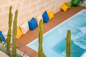 Cushions leaning on a wall next to a rooftop pool