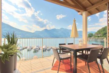 Balcony with outdoor table and chairs overlooking a lake