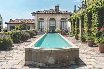 A long outdoor pool leading to a house