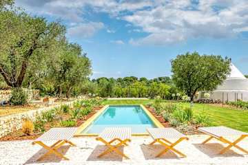 Four sun beds in front of a pool