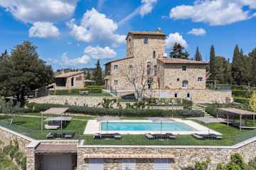 A swimming pool in front of an Italian farmhouse