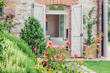 Door with open shutters surrounded by roses