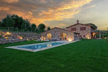 Swimming pool next to a villa at night