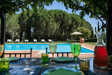Outdoor table with wine glasses next to a pool