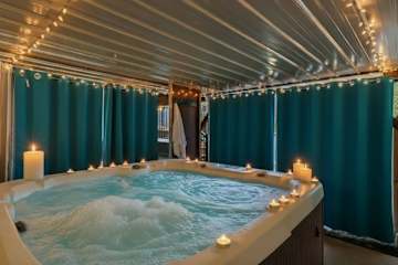 Candlelit and twinkling with string lights, this private hot tub is made for the most romantic soak of your trip 🕯️💙
