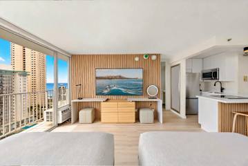 Bright twin beds with panoramic ocean and skyline scenery
