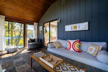 Comfortable couch and chair in the sunroom—ideal for lounging and enjoying the peaceful surroundings with plenty of space for all!