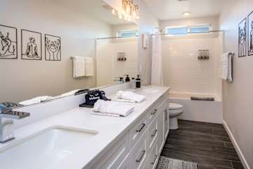 Hallway full sized bathroom with dual vanity
