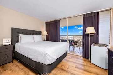 Stylish room filled with natural light, opening to a private balcony overlooking lush scenery