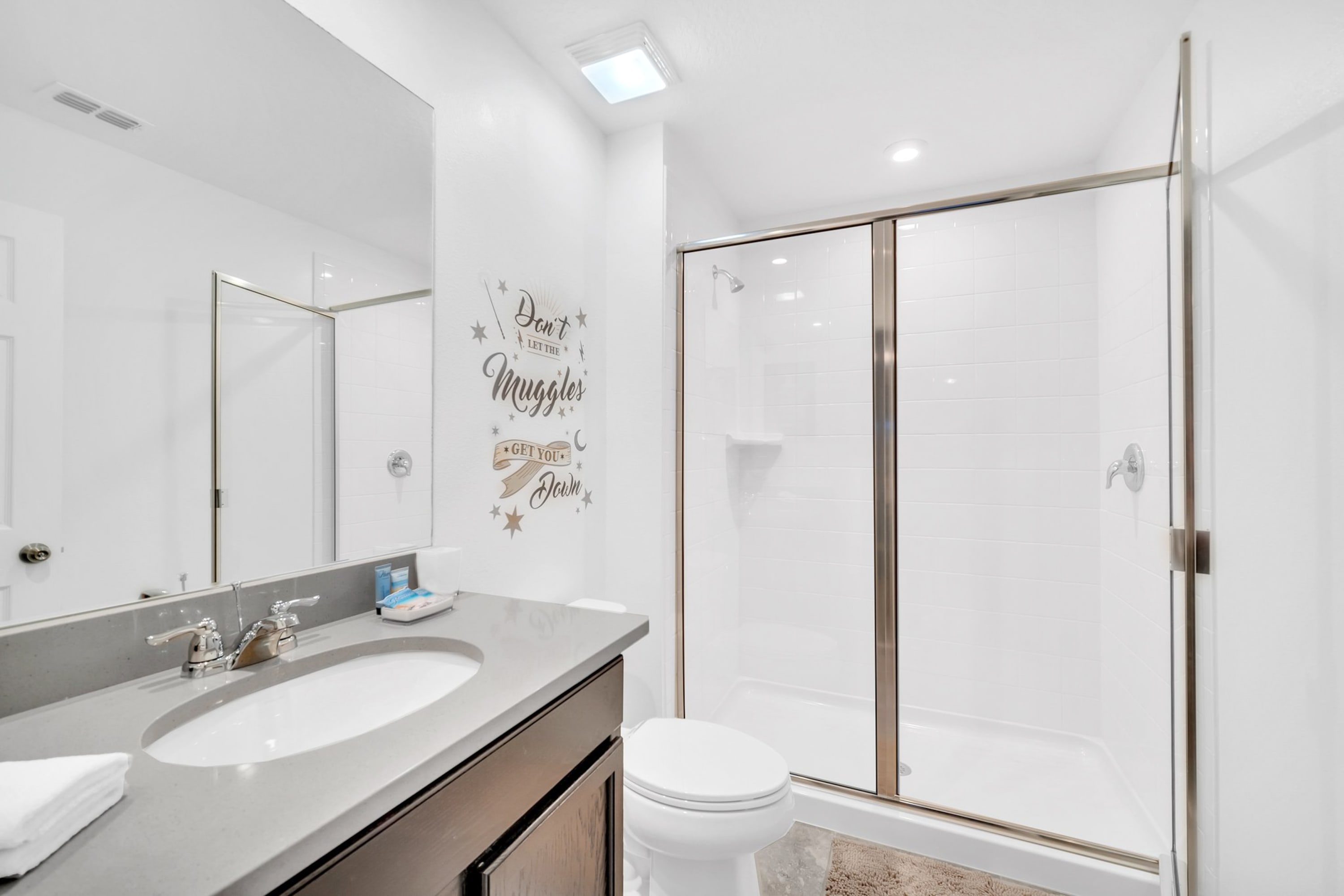 Bright Bathroom Featuring Dual Vanity And Glass-Enclosed Shower