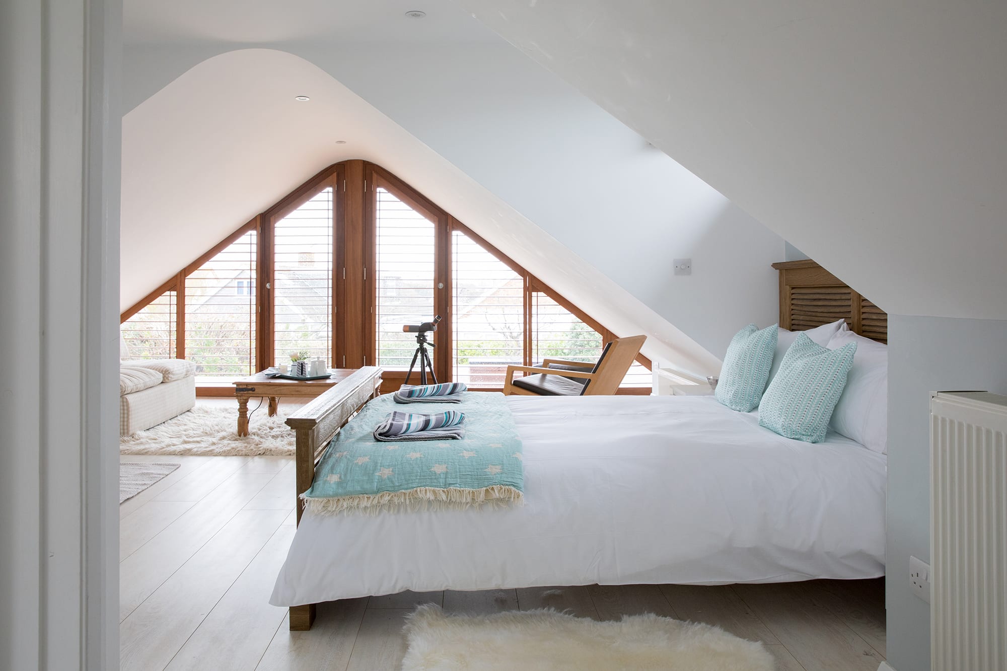 Let's start at the Master Bedroom on the upper floor! Its complete glass gable end allows you to marvel at the beautiful sunrise while sipping your morning coffee