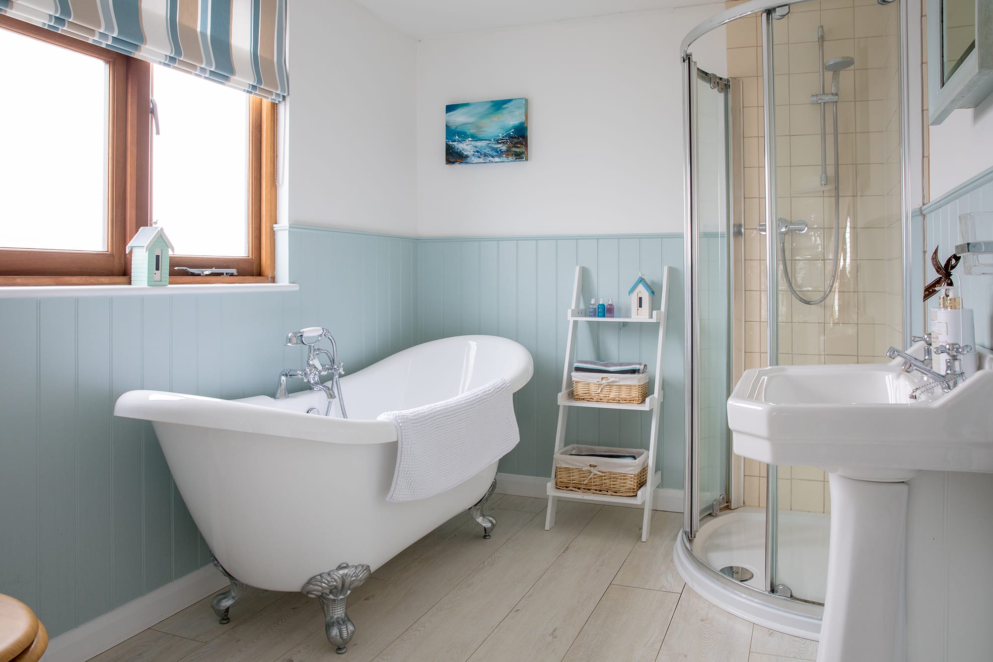 The first floor bathroom offers a vintage free-standing bathtub and a modern shower cabin.