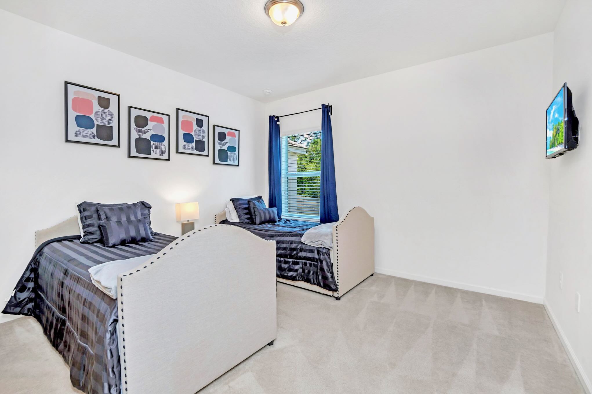 Bright Room Featuring Twin Beds And Entertainment Setup